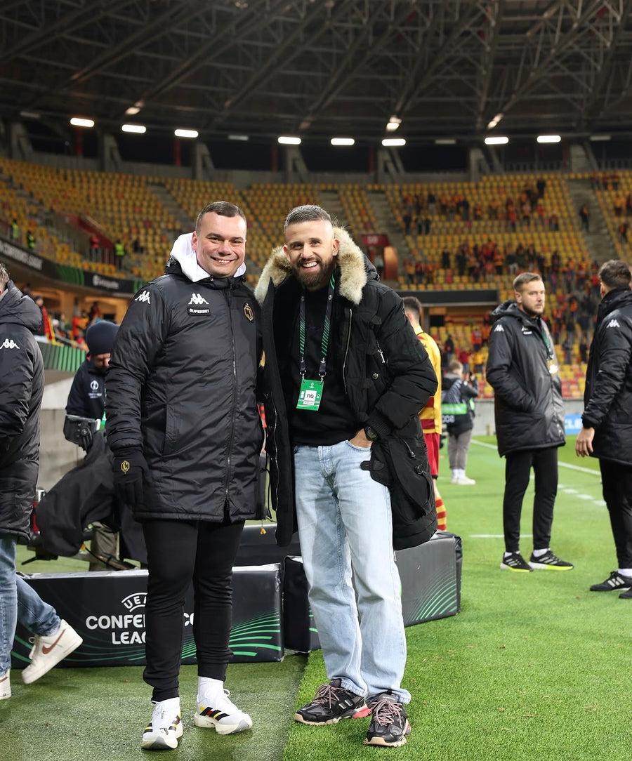Mateusz z trenerem Adrianem Siemieńcem na stadionie.